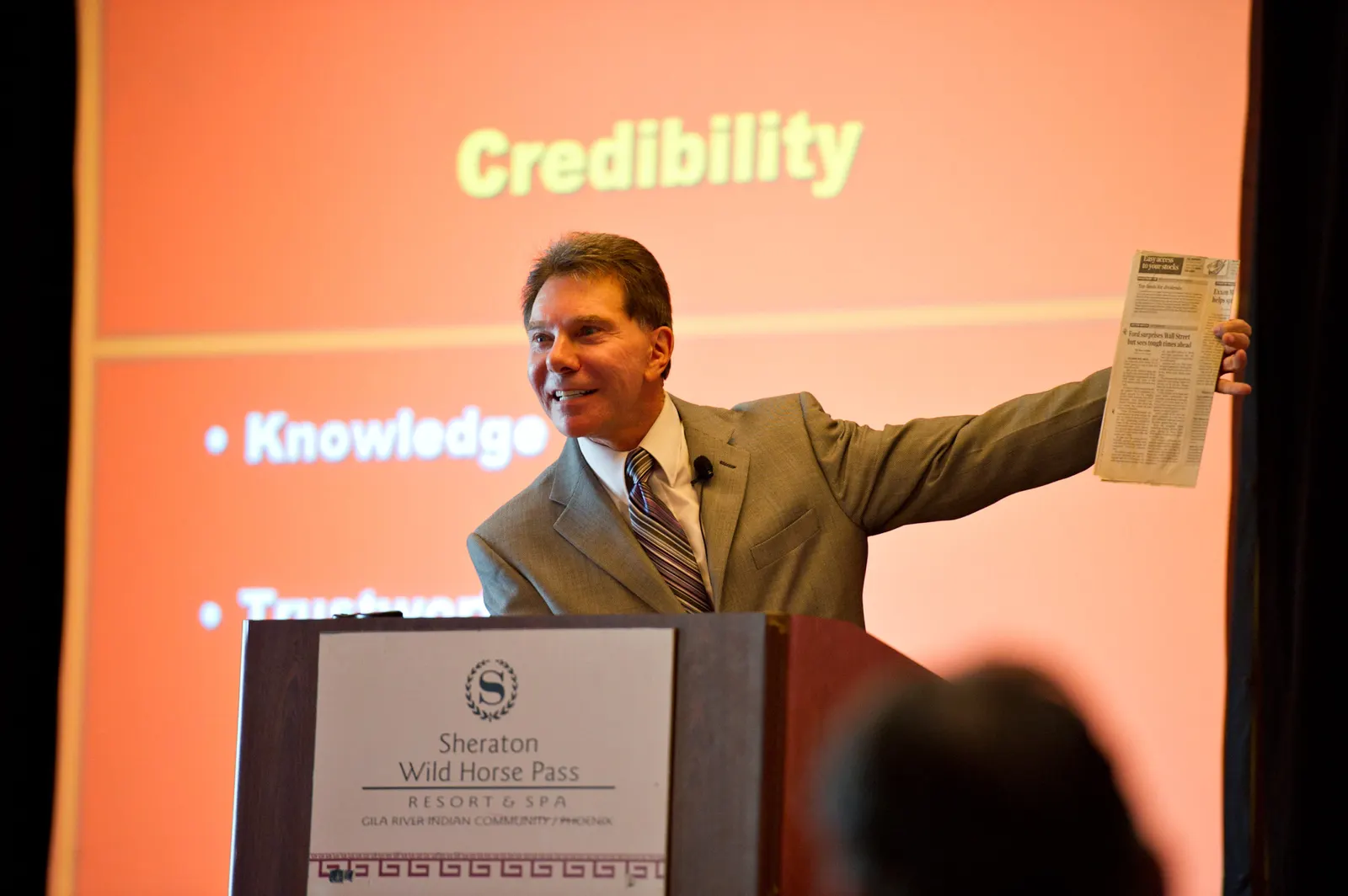Dr. Robert Cialdini at a podium presenting a slide titled Credibility