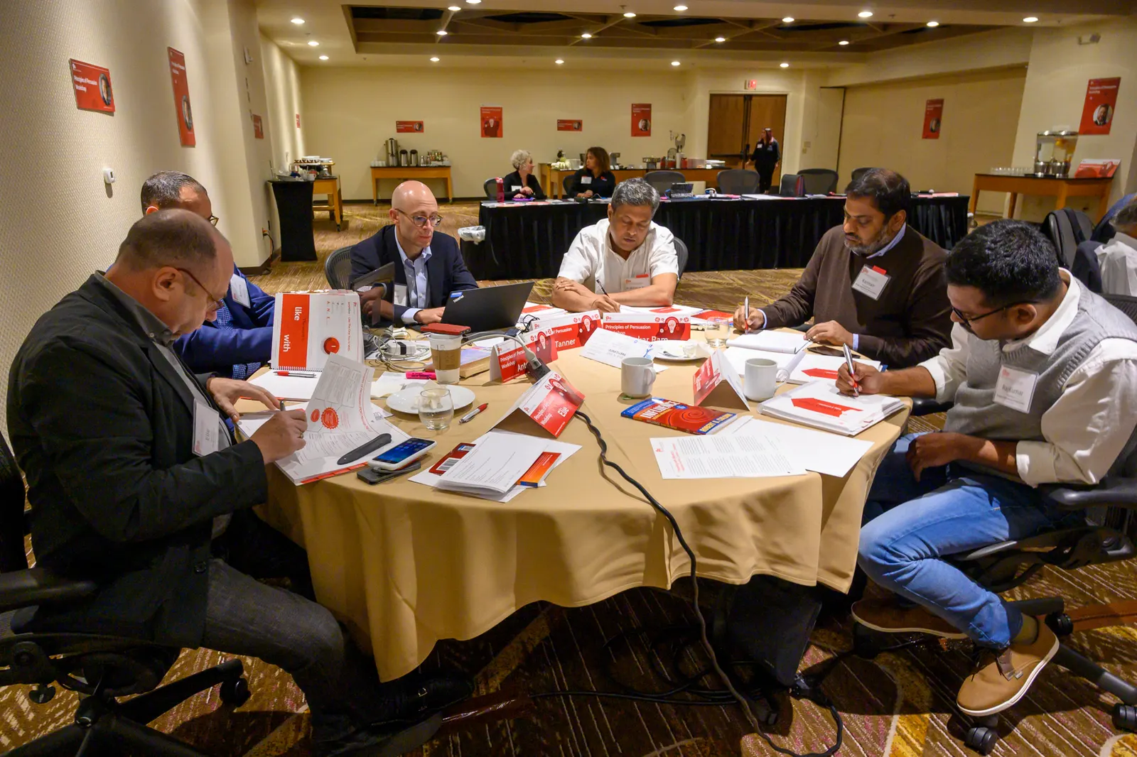Participants working through exercises around a table at a POP workshop