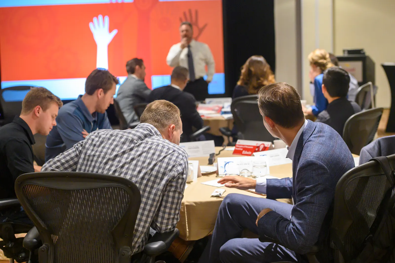 A facilitator leading a Principles of Persuasion session in front of a large screen